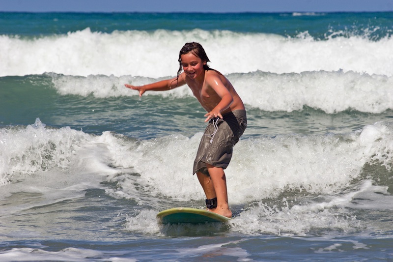 A young caucasian male learns to surf on Whangaehu Beach, Central Hawkes Bay, New Zealand